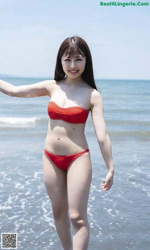 A woman in an orange bikini sitting in a pool.