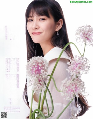 A woman holding a bunch of white orchids in her hands.