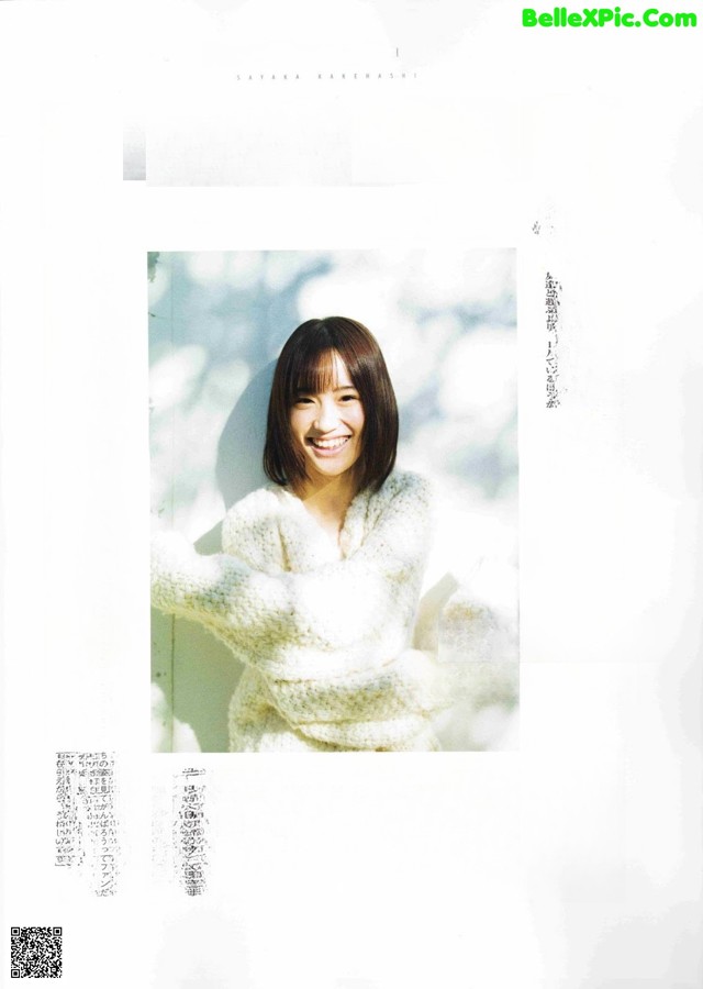 A woman in a white sweater is smiling in a magazine.