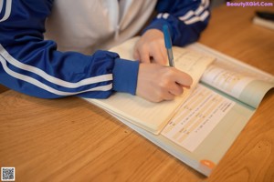 A woman sitting at a table with her head in her hands.