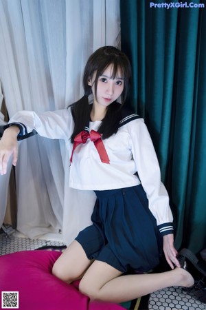 A woman in a school uniform waving at the camera.