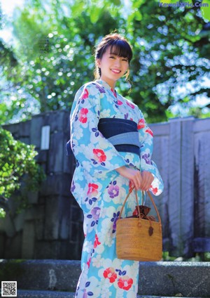 A woman in a blue and pink kimono posing for a picture.