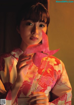 A woman in a pink kimono laying on the floor.