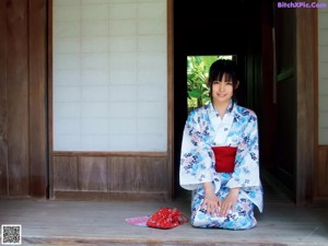 A naked asian woman with a towel wrapped around her body.