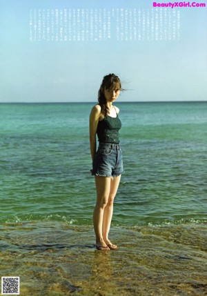 A woman in a green bikini posing for a picture.