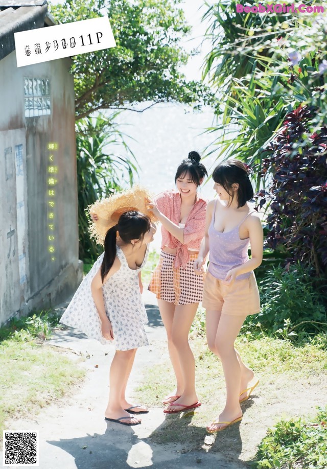 A group of young women standing next to each other on a dirt road.