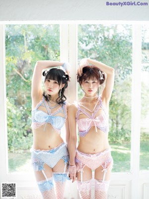 A couple of women sitting next to each other on a window sill.