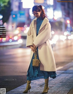 A woman with long brown hair is posing for a magazine.