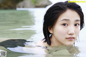 A woman in a black bathing suit and a straw hat.