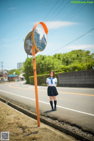 A naked asian woman in a school uniform posing for the camera.