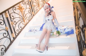 A woman in a blue and white dress holding a bouquet of flowers.