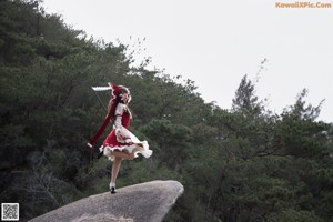 A woman in a red and white dress holding an umbrella.