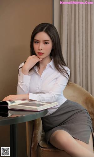 A woman in a white shirt and panties posing for a picture.