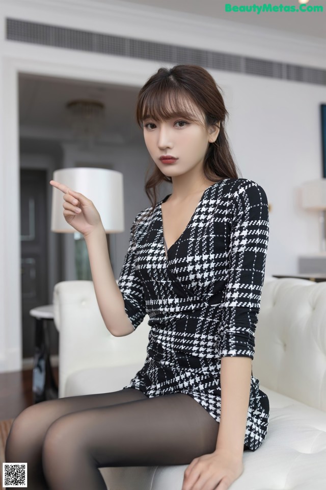 a woman sitting on top of a white couch