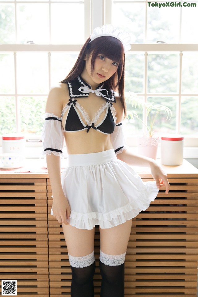 A woman in a maid outfit posing for a picture.