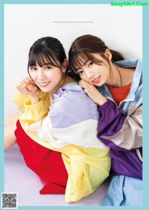 A couple of young women laying on top of each other.