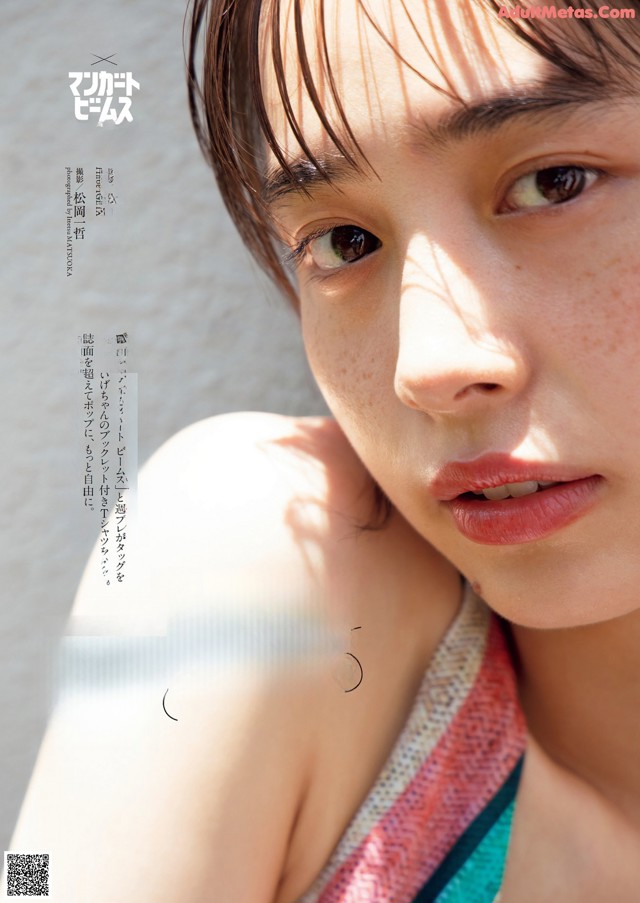 A woman with freckles on her face is posing for a magazine.