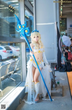 A woman dressed in a white and blue outfit holding a sword.