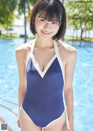 A woman in a blue bikini sitting in a bathtub.
