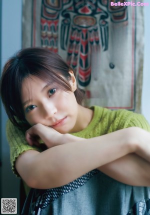 A poster for a Japanese movie with a woman in a green sweater.