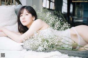 A woman laying on a couch with a bunch of flowers.